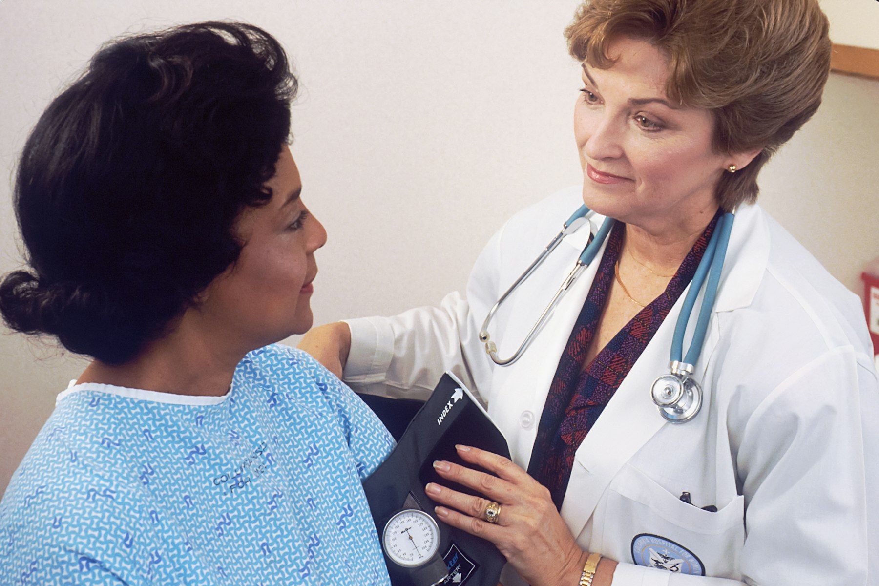 A doctor takes a woman’s blood pressure