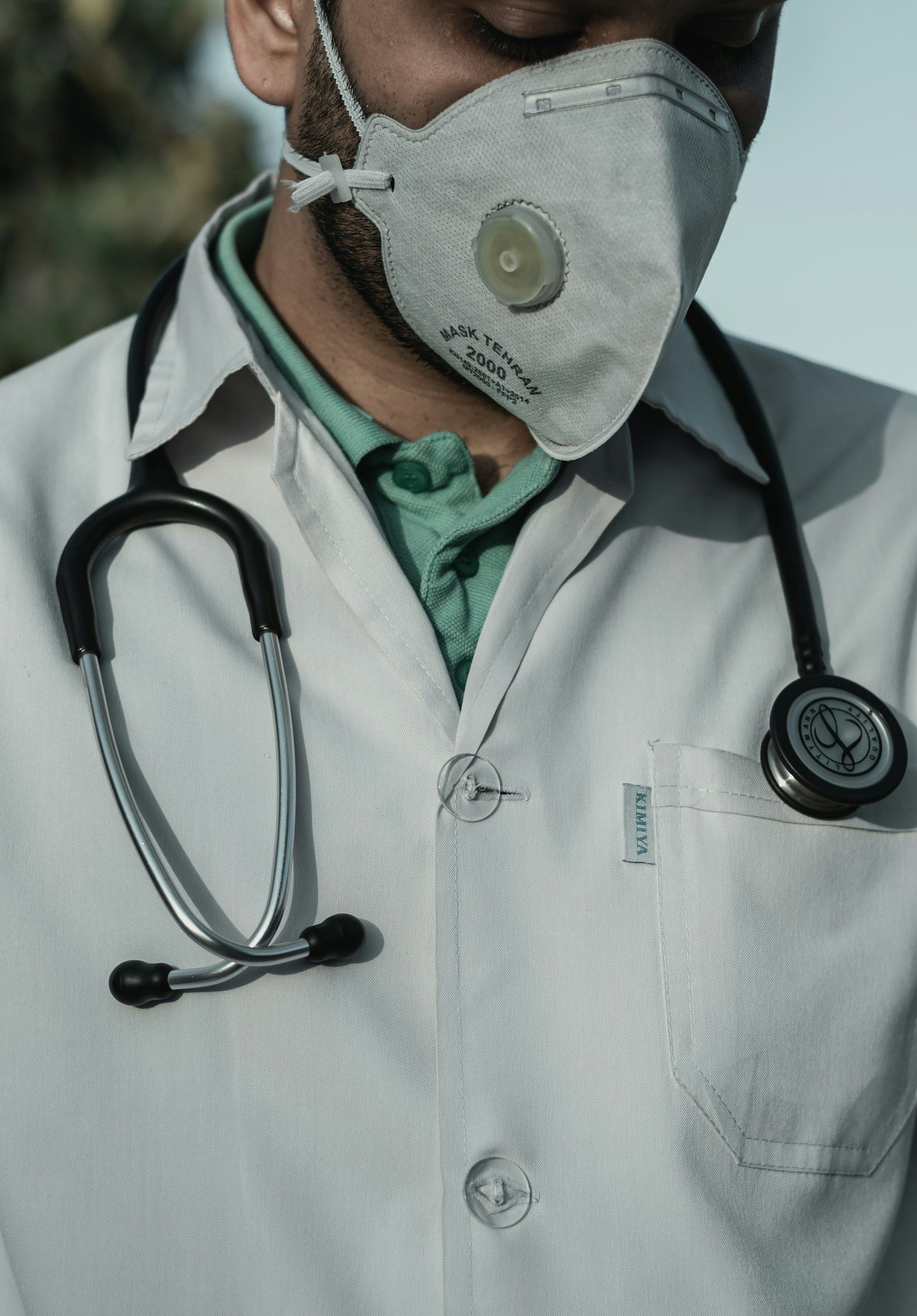 A clinician in a white coat with a stethoscope round the neck