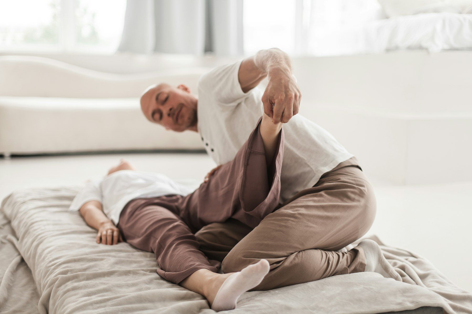 An older man works through a stretch at home