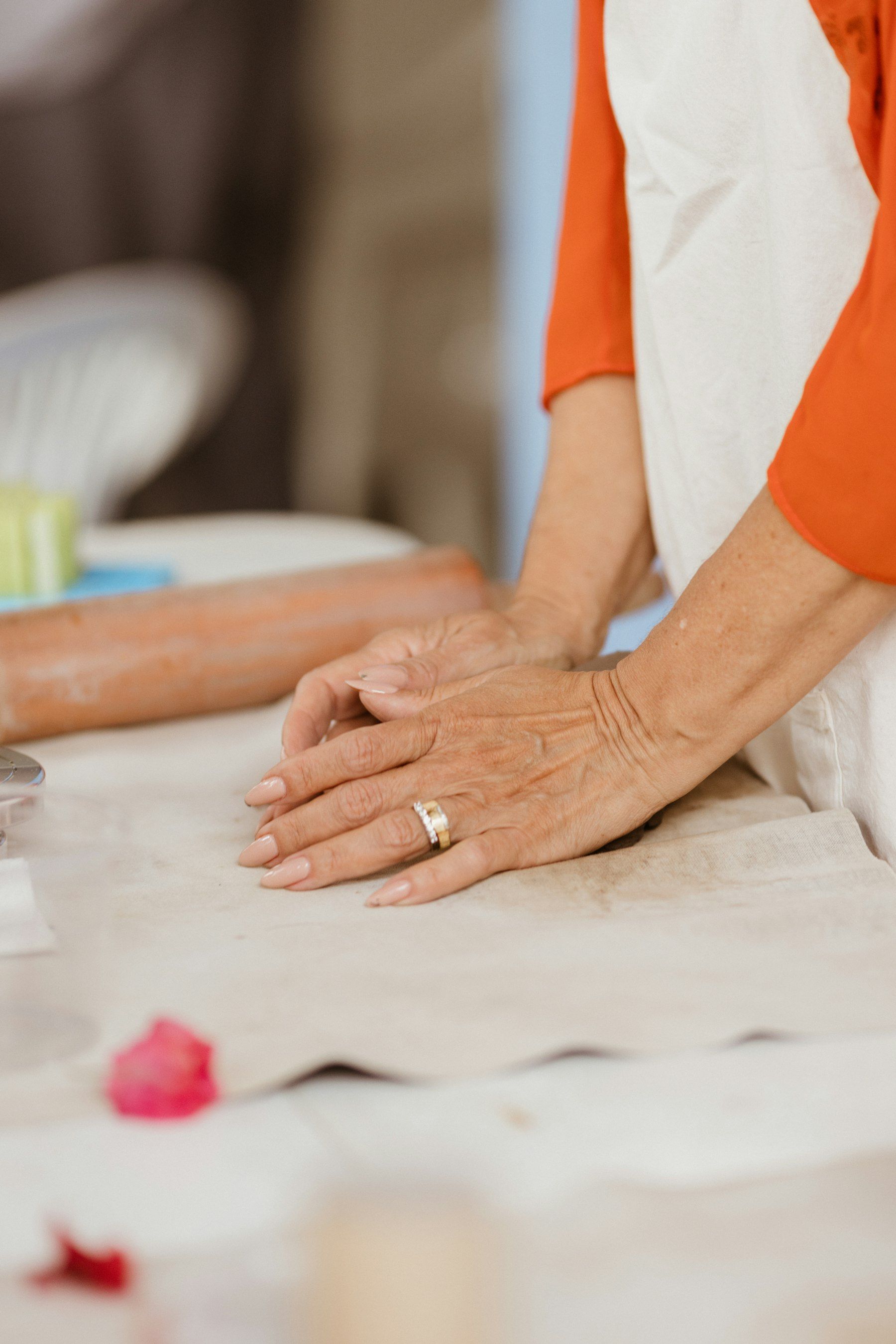 A carer’s hands rest over an older person’s hands