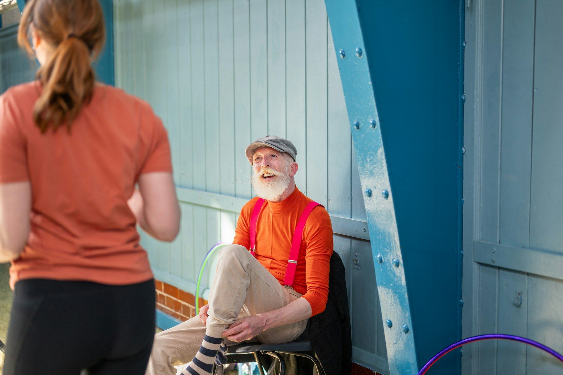 A therapist works with a smiling older man in a chair